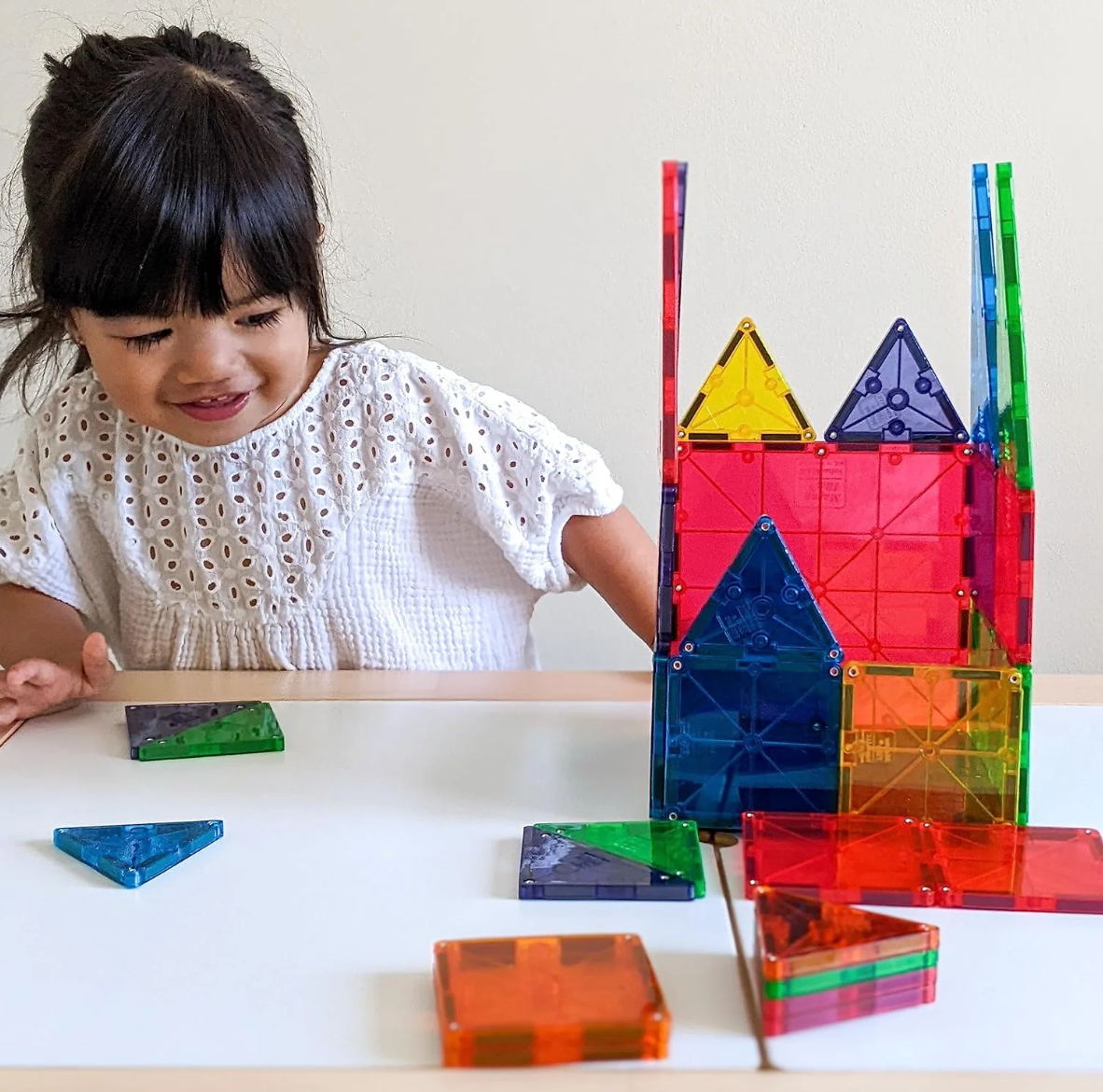 Child building a castle with magnetic tiles
